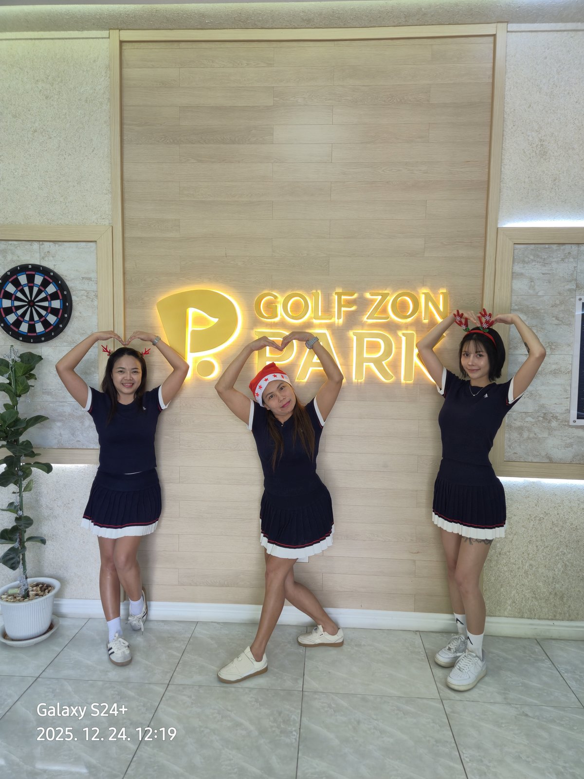 Members posing at the Golfzon Park neon sign